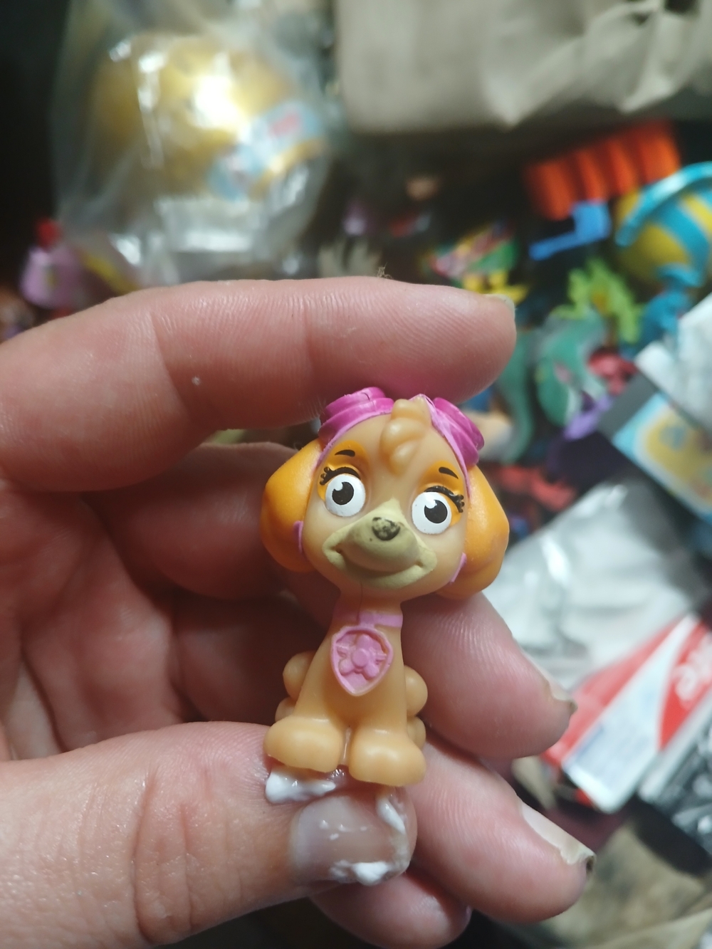 small, cream and orange Paw Patrol Mini Figure Skye wearing pink goggles.